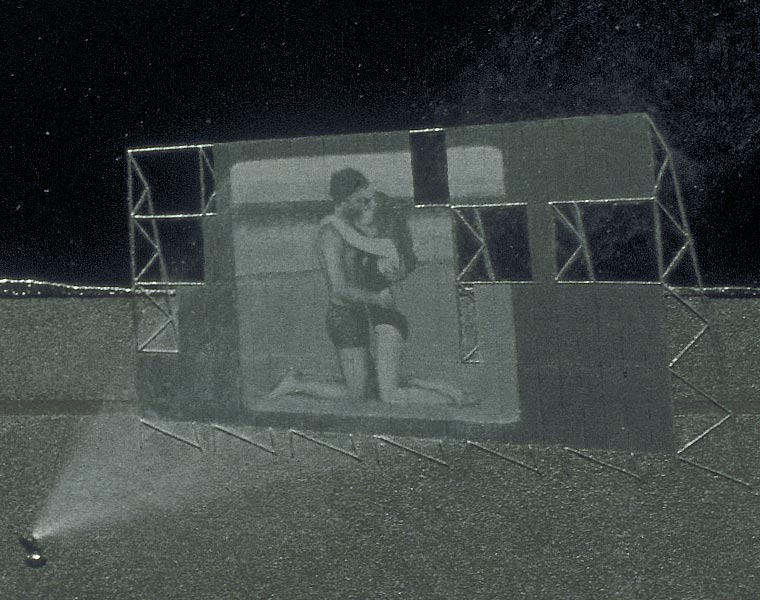 Detail of a painting of two ruined drive-in theaters, focusing on the screen with couple kissing